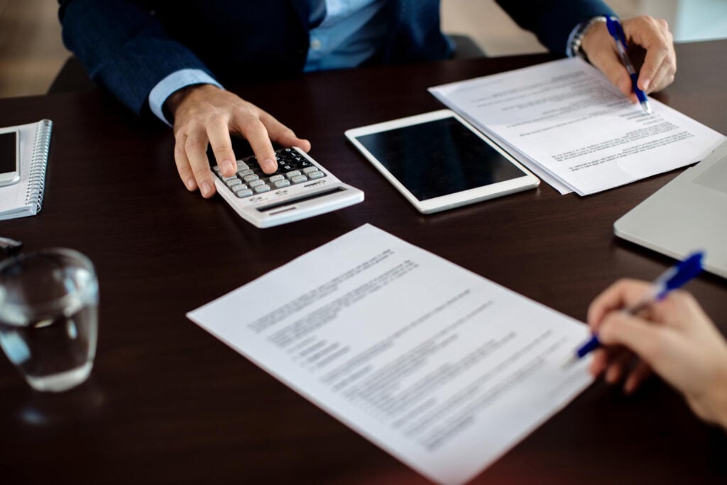 Client signing a document across the desk from an advisor